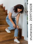 Small photo of Woman loses control and cannot walk on stairs, she stops and hold her knees for support and rest with feel tingling. Concept of Guillain barre syndrome and numb legs disease or vaccine side effect.