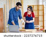 Asian Indian professional male and female engineer architect foreman labor worker lover couple wear safety goggles standing cuddling leaning together holding wooden home model in construction site.