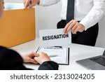 Small photo of The male employee holding a box containing his personal belongings, handed over his resignation letter to the supervisor, signifying the end of his chapter within the company.