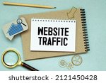 Memo note written with text WEBSITE TRAFFIC isolated on green background