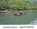 Small photo of 3 April 2018 Hunan Fenghuang (Phoenix) Ancient Town, China : A boat taking tourists rolling along the Tuojiang River in Fenghuang village which was added to the UNESCO World Heritage Tentative List