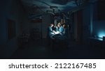 Small photo of Lviv, Ukraine - February 8, 2022: Doctors in uniform perform surgery in the operating room on dark background. Operation in modern hospital. Innovation technology system. Professional doctor group.