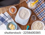 Small photo of Flour on digital kitchen scale with cookie ingredients for baking on wooden table, weight 150 g