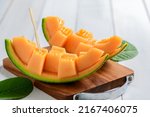 slice of japanese melons, orange melon or cantaloupe melon on white wood background, summer fruits