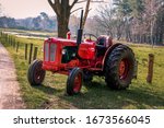 Old red vintage tractor on the land in the beautiful landscape of Drenthe near Havelte	
