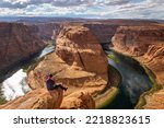 The famous horse shoe bend at Glen Canyon, with the Colorado River at the bottom surrounded by steep orange-red rocks, Arizona