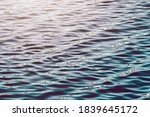 Waves on water surface. Bright water reflection on sunrise. Sea wave blue water ripple texture with dark and light surface.