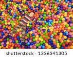 Emotional cheerful little child having fun in entertainment game center. Happy baby boy lying in pool filled with lot of colorful foam rubber balls in children