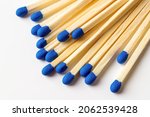 Small photo of Blue wooden matches on a light gray background. Matchsticks with bright blue heads macro. Scattered wooden matches without box close-up. Design element for smoker accessory concept. Top view.