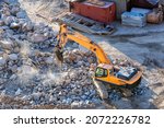 Small photo of A breaker with excavator is breaking to rocks in the construction site. A breaker is a powerful percussion hammer fitted to an excavator for demolishing hard (rock or concrete) structures.