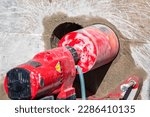 Small photo of Worker is drilling to concrete wall with core drill machine. core drill is a drill specifically designed to remove a cylinder of material, much like a hole saw. The material left inside the drill bit.