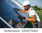 Small photo of Portrait of african american electrician engineer in safety helmet and uniform installing solar panels