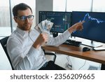 Small photo of Holding Dollar bills in the stock market. Investors counting money after making it big on the stock market. becoming rich and wealthy. online stock market information