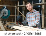 Small photo of Skilled cabinet maker cutting wood board with electric circular saw at woodworking sawmill. Professional cabinet maker use circular saw at sawmill factory. Wooden furniture production