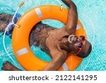 Small photo of Happy senior man having party in the swimming pool - Active elderly male person sunbathing and relaxing in a private pool during summertime