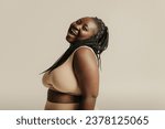 Small photo of Voluptuous young African woman in underwear radiating joy and self-love on studio background
