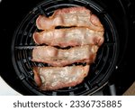 Small photo of Top view of fatty bacon strips in air fryer