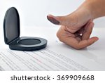 Small photo of Signing a contract with a thumb print: Image contains thumb with ink stain with paper and ink stamp pad.