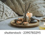 Burning candles, aroma fragrance natural organic diffuser, wooden bamboo tray. Concept of cozy home space for meditation, relaxation, detention. Spiritual aura cleansing routine for full moon ritual