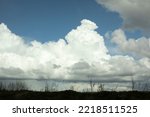 White clouds over forest. Celestial landscape in spring. View of natural landscape.