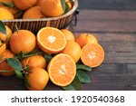 Small photo of Orange fruit with green leaves on the wood. Home gardening. Mandarine oranges. Tangerine oranges. Orange color. Fresh orange juice.