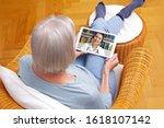 telemedicine concept, old woman with tablet pc during an online consultation with her doctor in her living room.