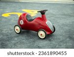 Small photo of Retro-style toy car on the playground. Retro-style beige toy car. Stylish toy for a toddler boy