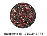 Bowl of dried aromatic peppercorns, isolated on white. Colourful pepper mix - black, red, green and white peppercorns. Top view.