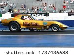 Small photo of Englishtown, NJ / USA - July 30, 2006: The Mini Vette classic Corvette funny car makes a high-speed pass down the track during a vintage drag racing event.