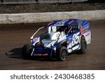 Small photo of Middletown, NY, USA - October 22, 2022: Michael Greg Sleight wrestles his Dirt Modified stock car around New York's Orange County Fair Speedway. Car slightly blurred to show speed and action.