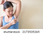 Woman plucking armpit underarm with tweezers. Hygiene skin body care and beauty. Healthcare and medicine concept.
