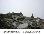  Stones stacked on top of each other in a pillar. Against the white cloud backdrop.Stone piles on top of each other, Slovakia. High Tatras national park                            