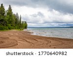The sandy shore of Clear Lake in Wasagaming, Manitoba on a cloudy day