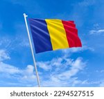 Flag on Chad flag pole and blue sky, Flag of Chad fluttering in blue sky big national symbol. Waving blue and yellow red Chad flag, Independence Constitution Day.
