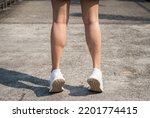 Small photo of Cropped shot of female runner standing on her tiptoes for strengthen her calves. Toe stretches can help keep you healthy and prevent common runner injuries.