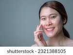 Small photo of Happiness Asian woman applying acne cream on her face for treating acne and redness skin. Cause of redness maybe occur from allergy to skincare ingredients, heat, sun exposure, alcohol, acne etc.