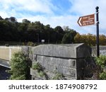 Small photo of Boyneside Trail directional sign (in English and translated directly into the Irish language) beside Saint Dominick's Bridge in Drogheda, County Louth, Ireland.