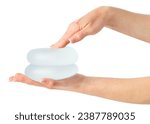 Hand pressing soft breast implants in hand isolated on white background with clipping path.