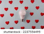 light love concept from hearts around light bulb on blue background minimalism.