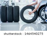 4 new tires that change tires in the auto repair service center, blurred background, the background is a new car in the stock blur for the industry, a four-wheeled tire set at a large warehouse