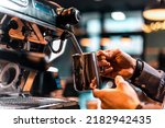 Barista pouring milk for prepare cup of coffee. Latte art. Morning cup of coffee in café. Brewing coffee. Coffee shop concept. Vertical photo