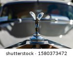 close up and selective focus on a hood, bonnet ornament, radiator cap, motor mascot or car mascot of a person with wings on classic vintage car