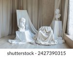Artisan workshop. Interior studio with Workspace of artist. White sculptures, plaster bust, marble statue and Gypsum head on concrete wall background. Creative painting Studio of artist with easel. 