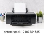 Small photo of Inkjet printer with blank paper sheet on office desk. Template mock up