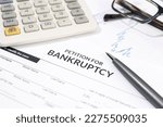 Bankruptcy form, calculator and pen on desk. Personal injury claim form