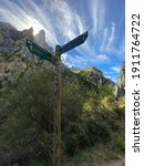 Small photo of Cain, Spain - September 1, 2020: Wooden signpost with directional signs on hiking trail in the Cares Route in the heart of Picos de Europa National Park, Cain-Poncebos, Asturias, Spain.