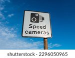 Speed camera warning sign with a bright blue sky behind