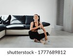 woman sitting floor smile after a workout, tired, water bottle positive brunette cute young