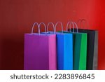 shopping bags, pink, blue, green and brown on orange background