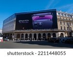 Small photo of Paris, France - October 7, 2022: Giant Apple iPhone 14 Pro advertising poster covering the scaffoldings of the restoration work on the facade of a parisian building housing an Apple store